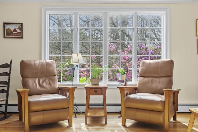 sitting room with baseboard heating and wood finished floors