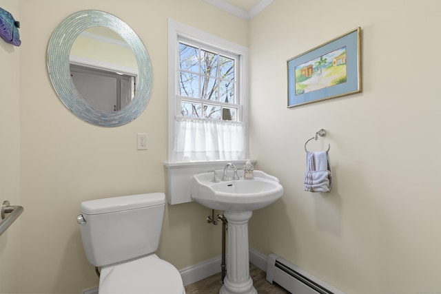 bathroom with crown molding, wood finished floors, a baseboard heating unit, baseboards, and toilet