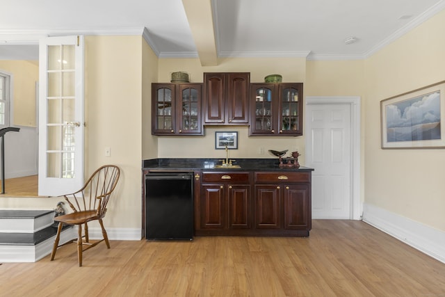 bar featuring light wood-style floors, bar area, baseboards, and ornamental molding