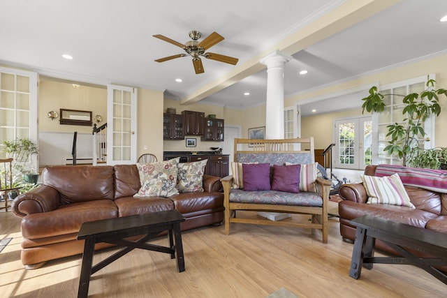 living area featuring french doors, decorative columns, light wood-style floors, ceiling fan, and ornamental molding