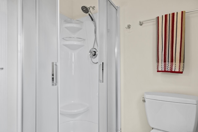 bathroom with a shower stall and toilet