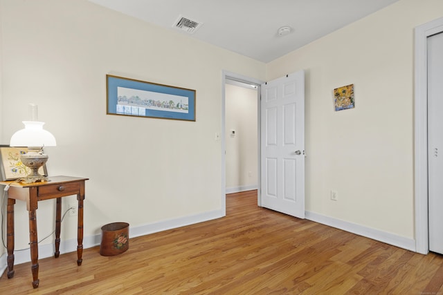 bedroom featuring baseboards, visible vents, and light wood finished floors