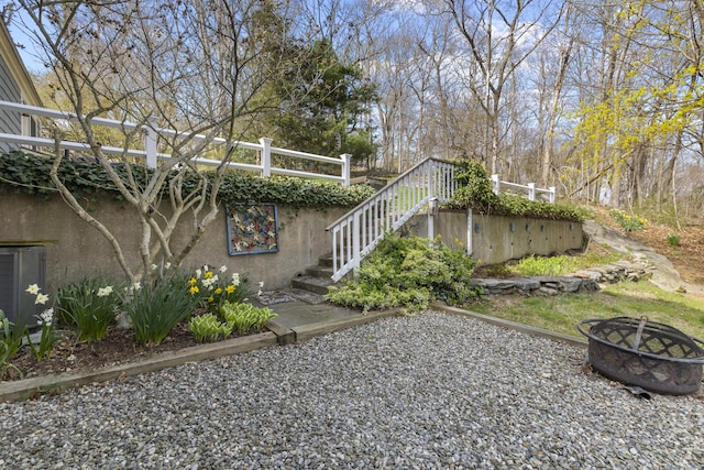 exterior space featuring cooling unit, stairway, and an outdoor fire pit