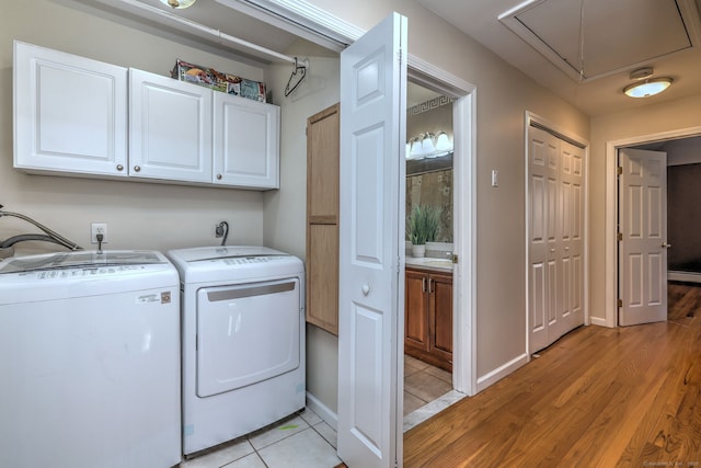 340 Webb Cir, Monroe, CT 06468 - clothes washing area with light wood finished floors, attic access, baseboards, separate washer and dryer, and cabinet space