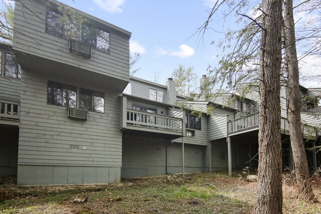 rear view of property with a chimney and a wooden deck