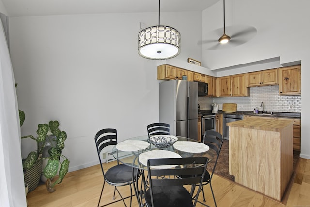 kitchen with wooden counters, light wood finished floors, stainless steel appliances, and tasteful backsplash