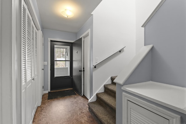 doorway featuring finished concrete flooring and stairway