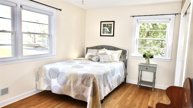 bedroom featuring visible vents, wood finished floors, and baseboards