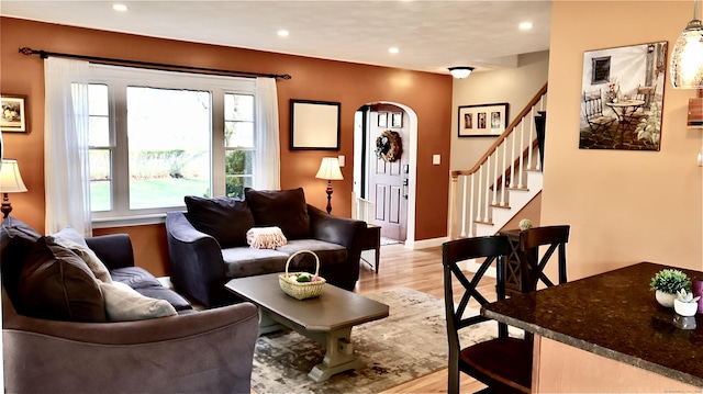 living area with a healthy amount of sunlight, light wood-type flooring, recessed lighting, and arched walkways
