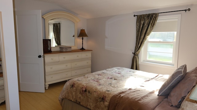 bedroom featuring lofted ceiling and light wood-type flooring
