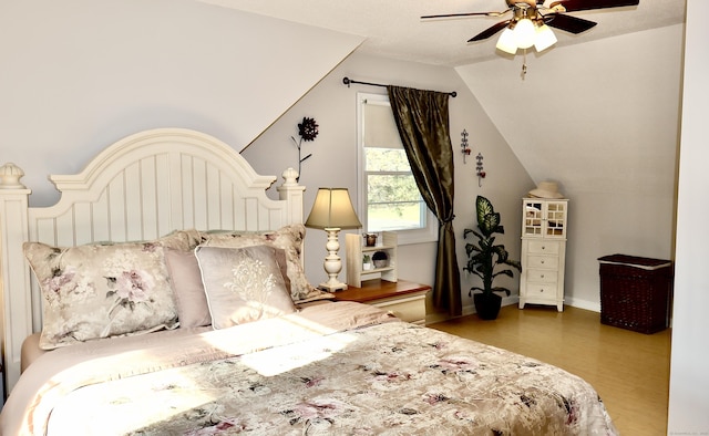 bedroom with baseboards, wood finished floors, a ceiling fan, and lofted ceiling