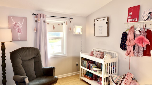 sitting room featuring lofted ceiling, wood finished floors, and baseboards