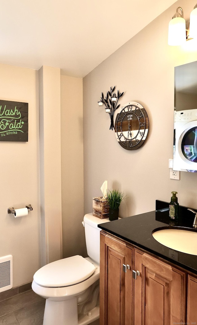 bathroom featuring toilet, washer / dryer, visible vents, and vanity