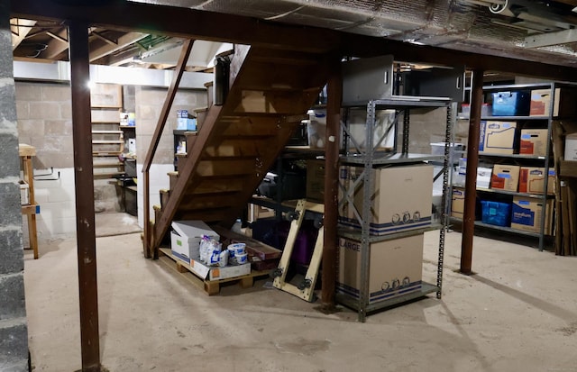 unfinished basement with stairway and concrete block wall