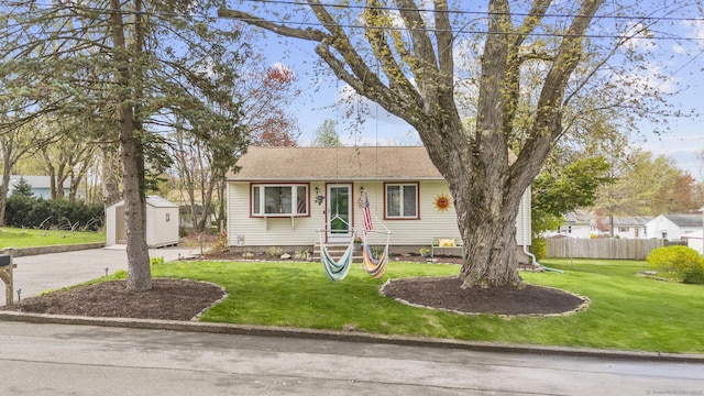98 Cynthia Dr, West Haven, CT 06516 - bungalow-style house with concrete driveway, a storage unit, an outbuilding, fence, and a front lawn