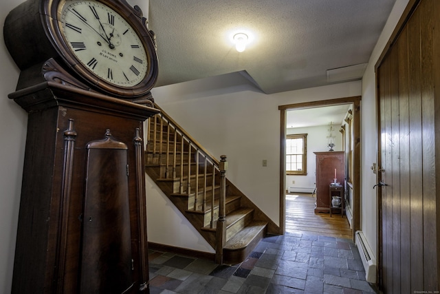 16 November Trl, Haddam, CT 06438 - staircase featuring a baseboard heating unit, baseboard heating, stone tile floors, baseboards, and a textured ceiling