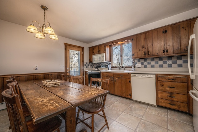 16 November Trl, Haddam, CT 06438 - kitchen with brown cabinets, a chandelier, white appliances, tasteful backsplash, and light countertops