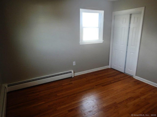 48 W Vine St, Stonington, CT 06379 - unfurnished bedroom featuring wood finished floors, baseboard heating, baseboards, and a closet