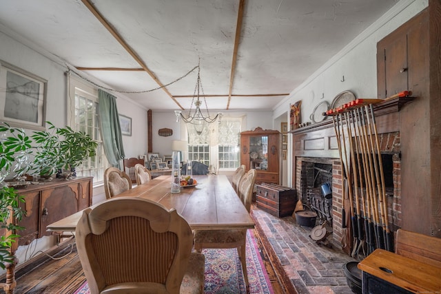 469 Platt Hill Rd, Winchester, CT 06098 - dining room with brick floor, a brick fireplace, crown molding, and an inviting chandelier
