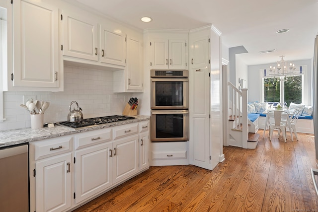 9 High Ridge Rd, Wilton, CT 06897 - kitchen featuring a chandelier, light wood-type flooring, appliances with stainless steel finishes, and white cabinets