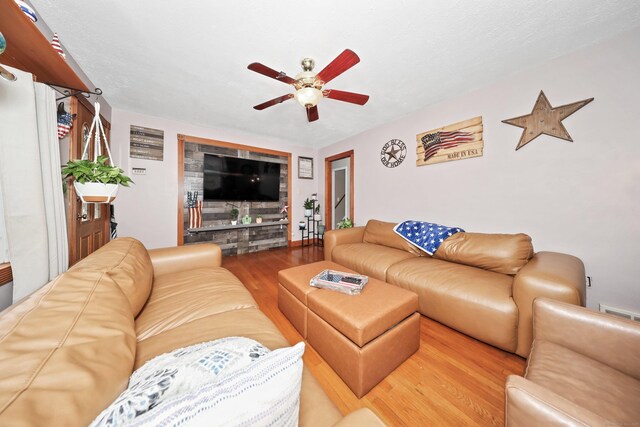 living room with wood finished floors and a ceiling fan