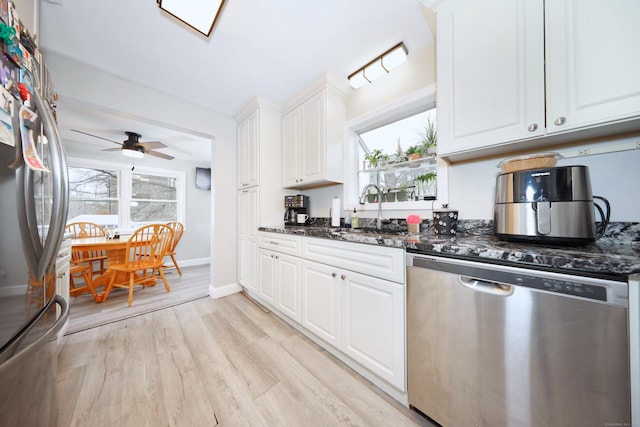 kitchen with light wood-type flooring, stainless steel appliances, a sink, and a healthy amount of sunlight