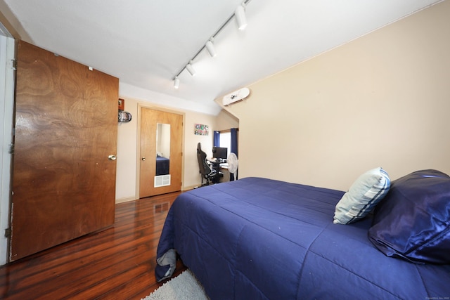 bedroom featuring track lighting and wood finished floors