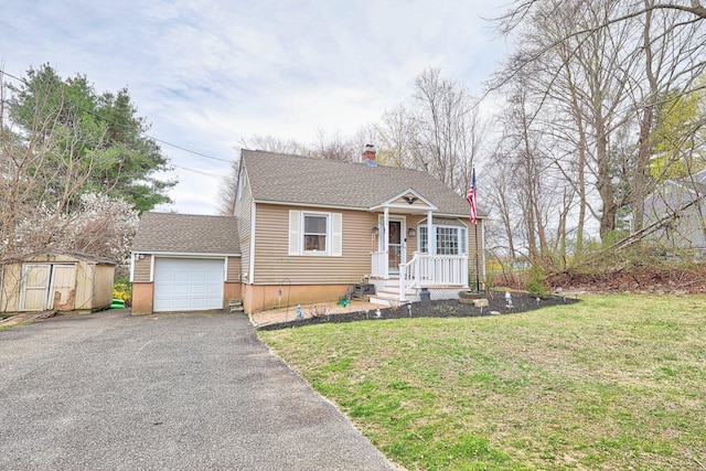 view of front of property featuring roof with shingles, driveway, an attached garage, an outdoor structure, and a front yard