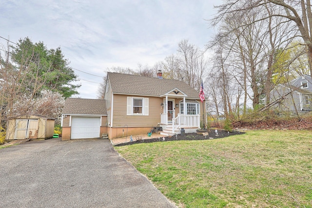 view of front of property featuring a front lawn, driveway, a garage, an outdoor structure, and a shed