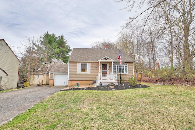 view of front of house featuring an outdoor structure, driveway, a front lawn, and roof with shingles