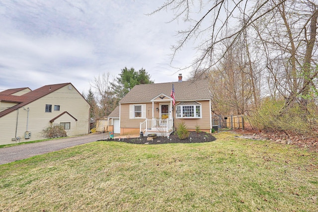 bungalow-style house with fence, a shingled roof, and a front yard