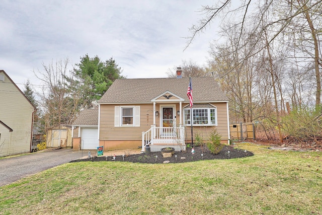 bungalow-style home with a shingled roof, a front lawn, driveway, and fence