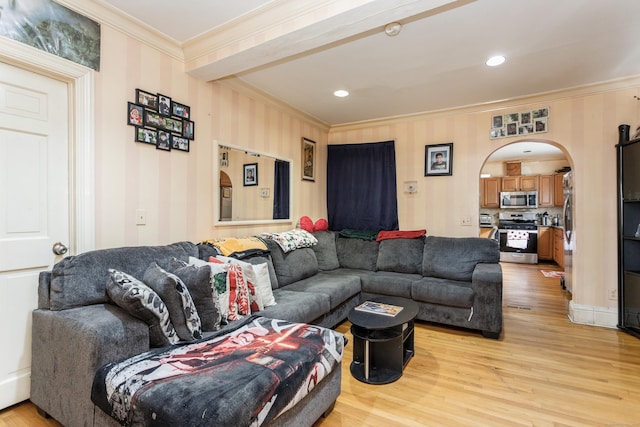 living room with arched walkways, crown molding, and light wood-style flooring