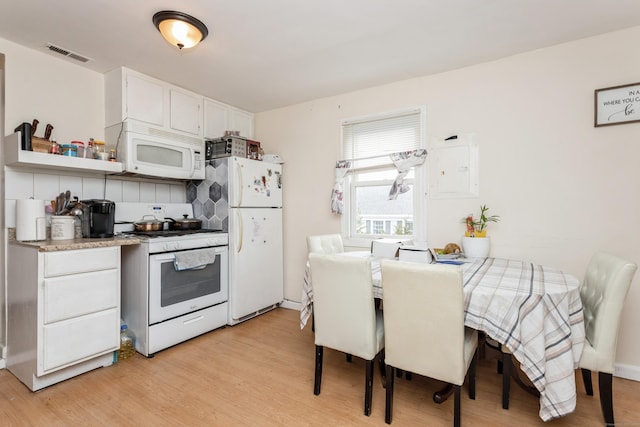 kitchen with light wood-style flooring, visible vents, white cabinetry, and white appliances
