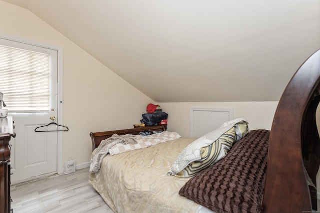 bedroom with vaulted ceiling and light wood-style flooring