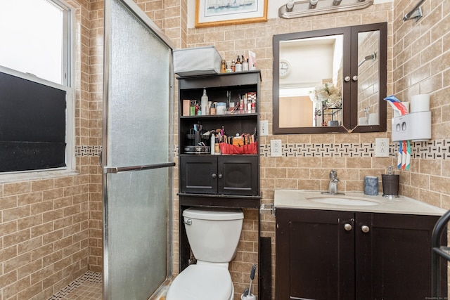 full bathroom with a shower stall, tile walls, toilet, and vanity