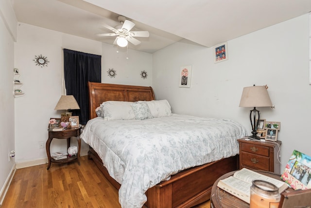 bedroom featuring baseboards, wood finished floors, and ceiling fan