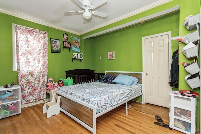 bedroom with ceiling fan, baseboards, crown molding, and wood finished floors