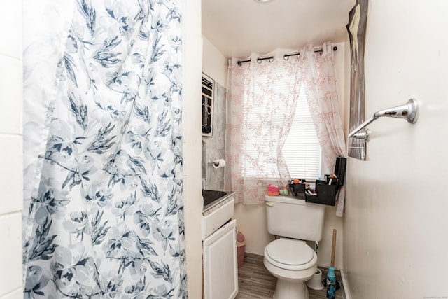 bathroom with a shower with shower curtain, wood finished floors, and toilet