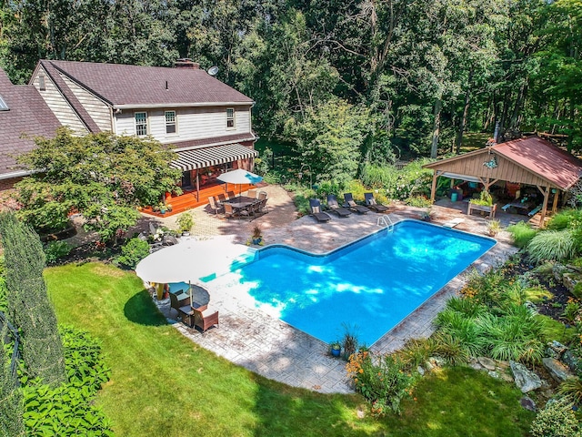 outdoor pool with a patio, a lawn, a deck, and a gazebo