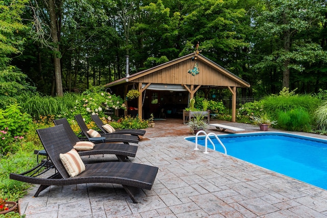 pool featuring a gazebo, a diving board, and a patio