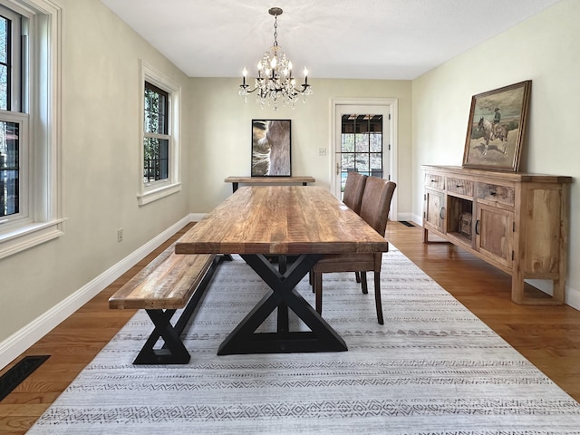 dining room featuring baseboards, a notable chandelier, and dark wood-style floors