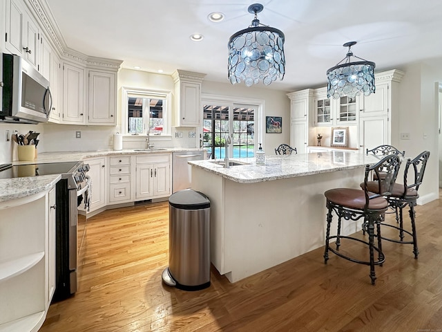 kitchen featuring a sink, a chandelier, stainless steel appliances, recessed lighting, and light wood-type flooring