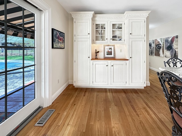 interior space with baseboards, light wood-type flooring, and visible vents