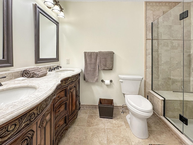 full bath featuring a sink, double vanity, toilet, baseboards, and a stall shower