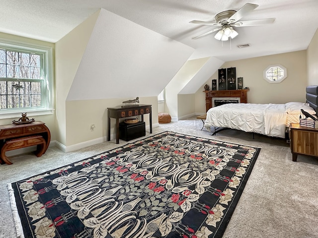 carpeted bedroom with multiple windows, lofted ceiling, a textured ceiling, and visible vents