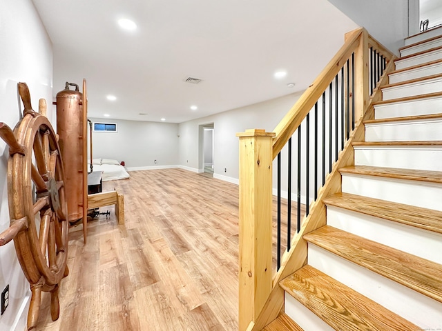 stairs with recessed lighting, baseboards, visible vents, and wood finished floors
