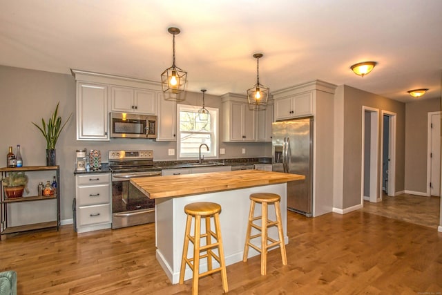 3 Henry Rd, Enfield, CT 06082 - kitchen featuring a kitchen breakfast bar, wooden counters, appliances with stainless steel finishes, a sink, and light wood-style floors