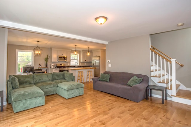 3 Henry Rd, Enfield, CT 06082 - living area with a healthy amount of sunlight, light wood-type flooring, and a notable chandelier