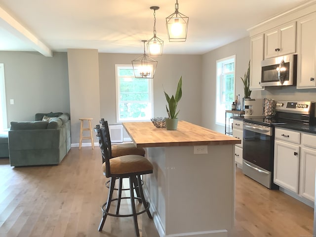 3 Henry Rd, Enfield, CT 06082 - kitchen with appliances with stainless steel finishes, butcher block counters, light wood-style flooring, and a center island